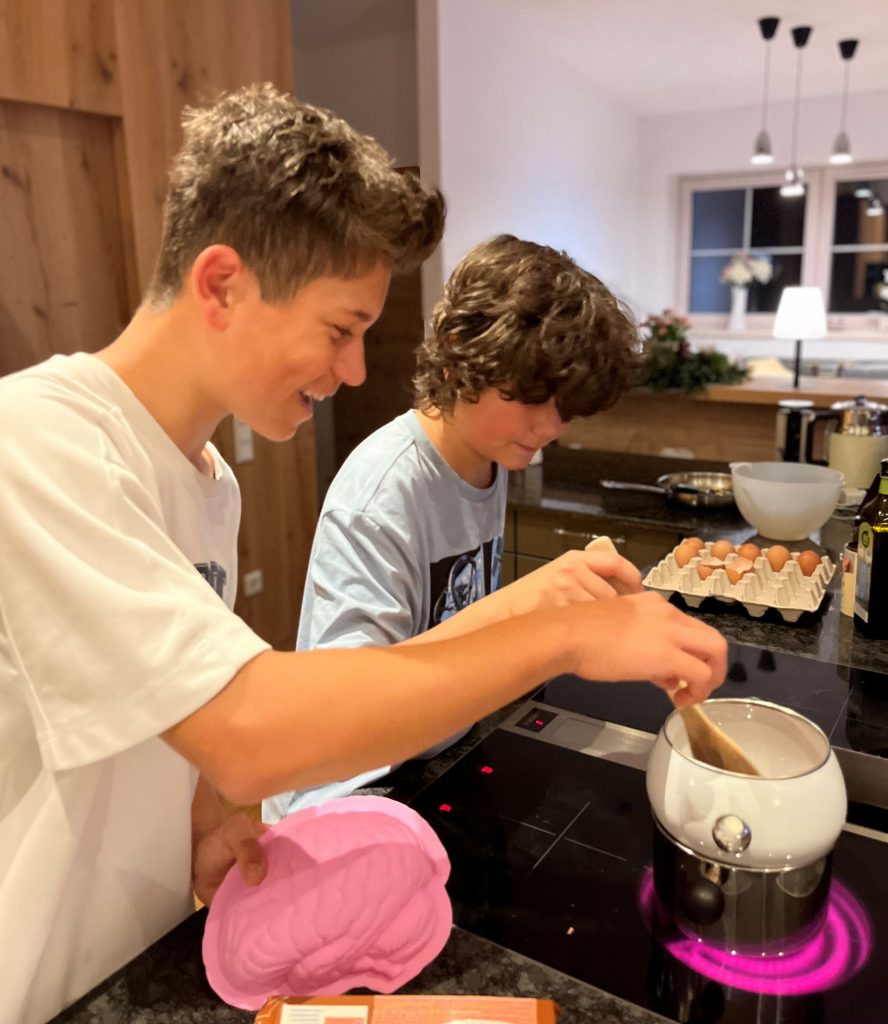 Two young boys laughing and baking together